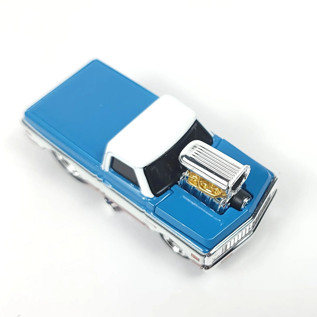 Top view of the die-cast 1972 Chevrolet C10 pickup truck model showcasing its blue and white color scheme and engine.