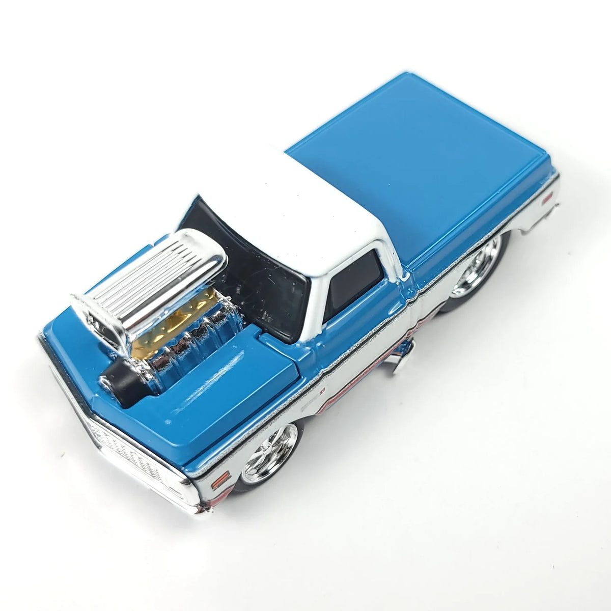 Top view of a blue and white 1972 Chevrolet C10 pickup truck scale model with a detailed engine.