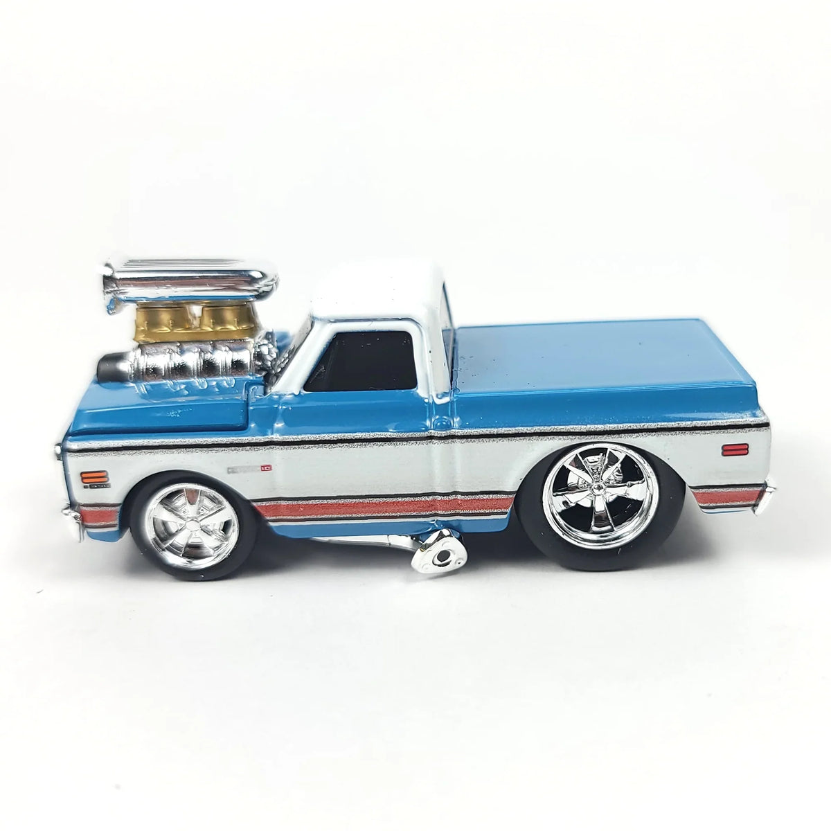 Side view of a blue and white 1972 Chevrolet C10 pickup truck scale model showcasing its wheels and engine.
