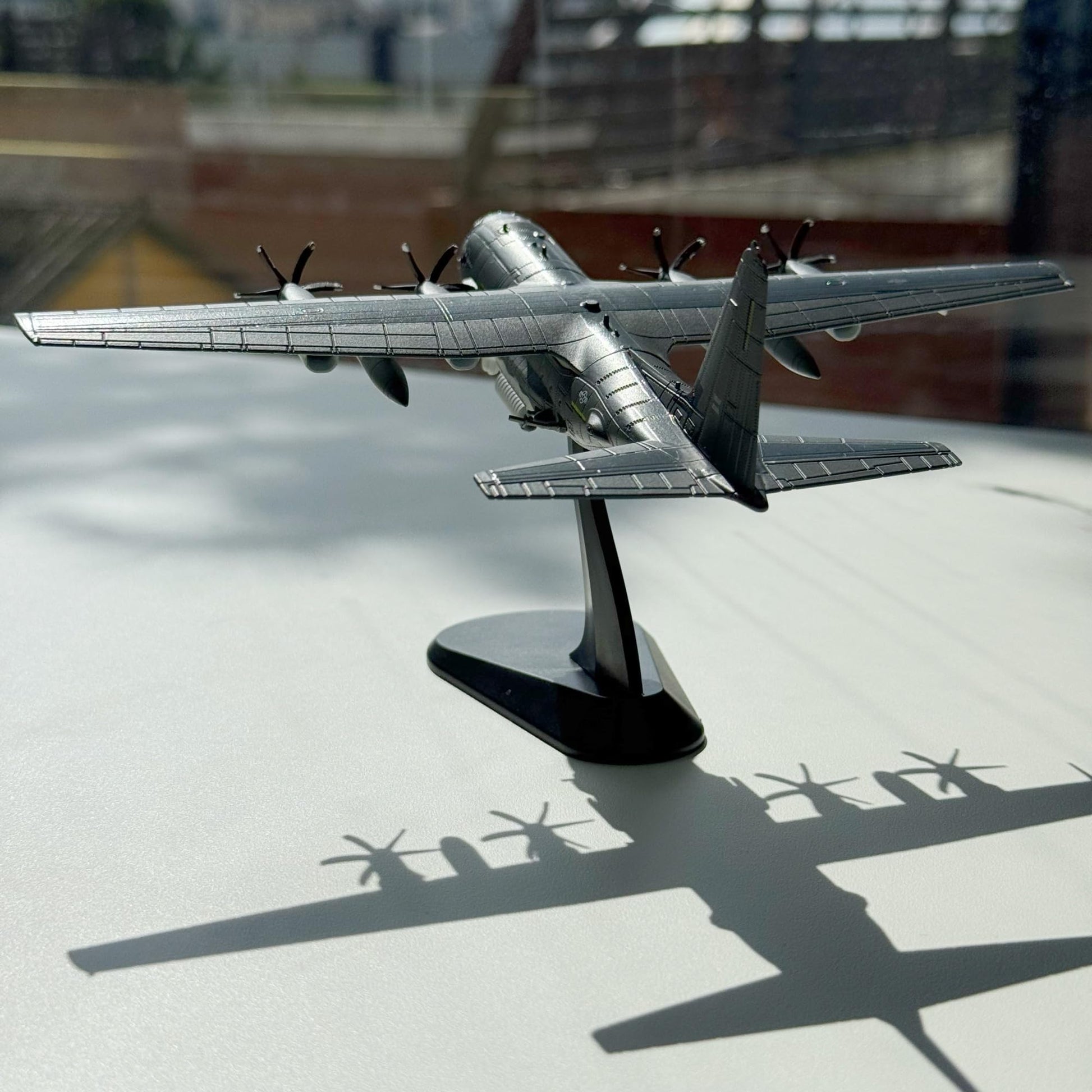 NUOTIE AC-130J Ghostrider model in gray, rear view showcasing propellers and stand