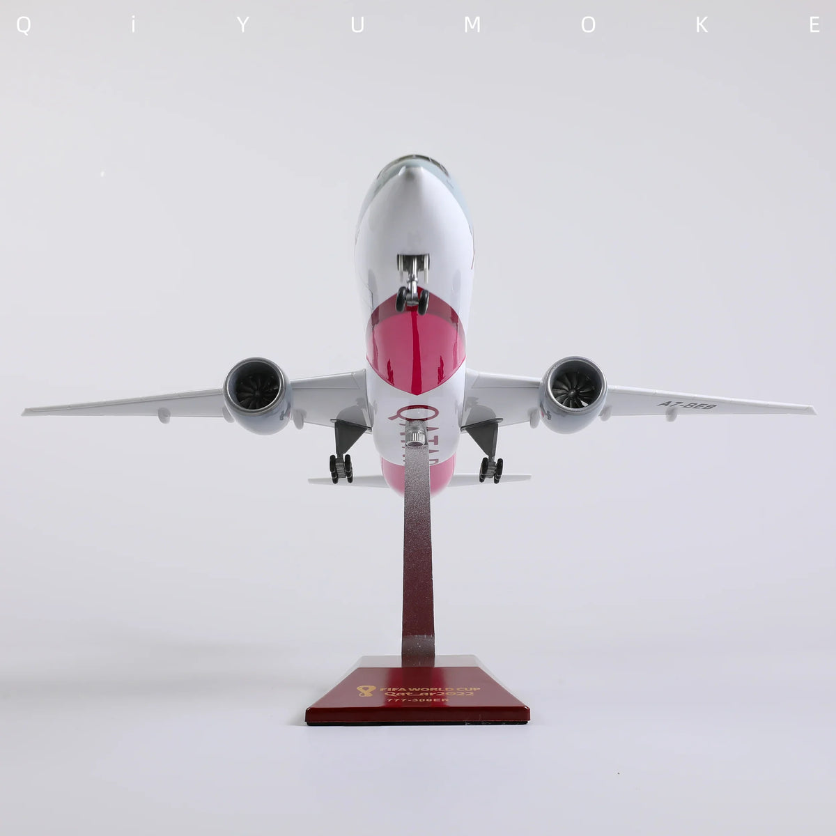 QIYUMOKE Boeing 777-300ER Qatar Airways diecast model on display stand, front view