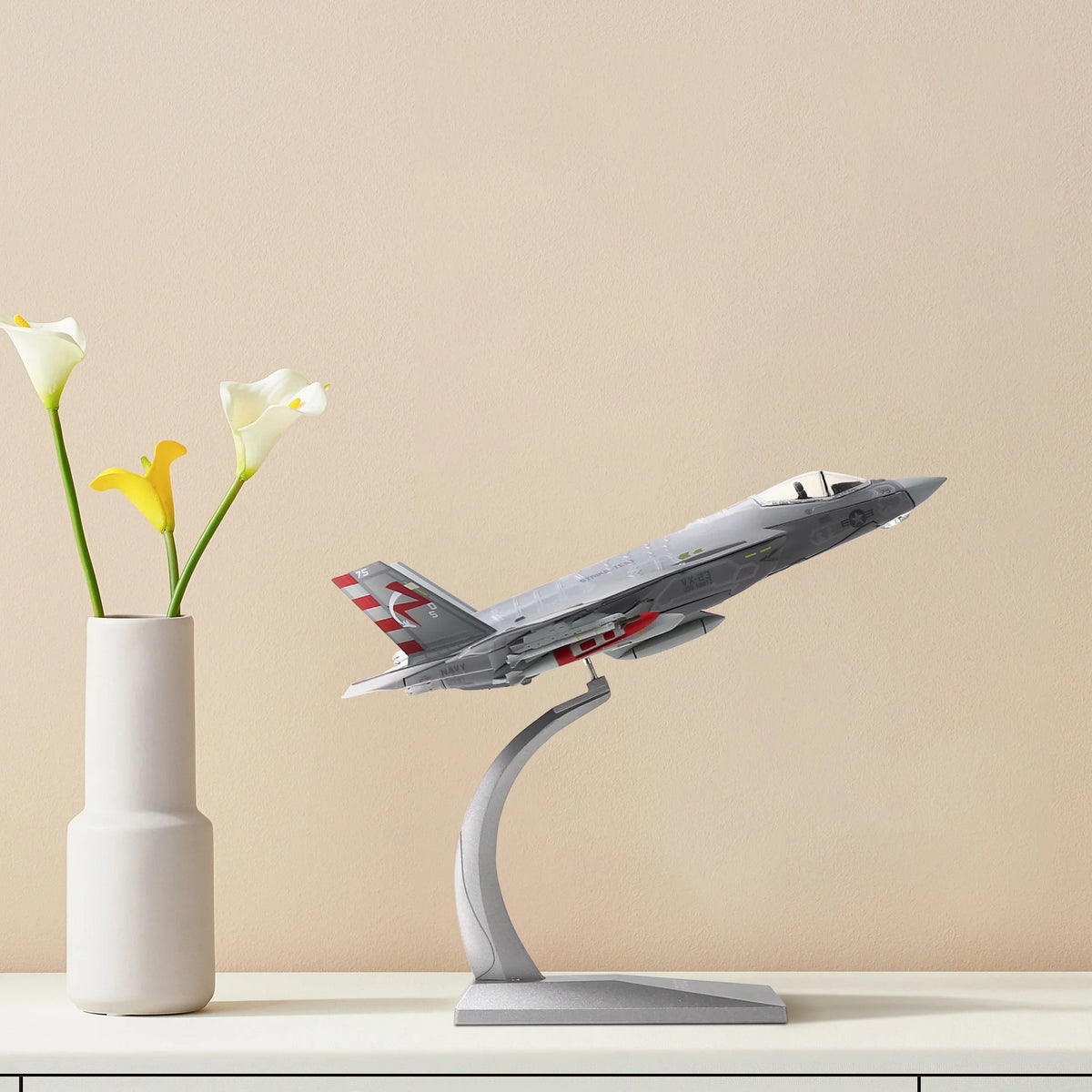 NUOTIE F-35C Lightning II diecast model in navy, displayed on a shelf with flowers