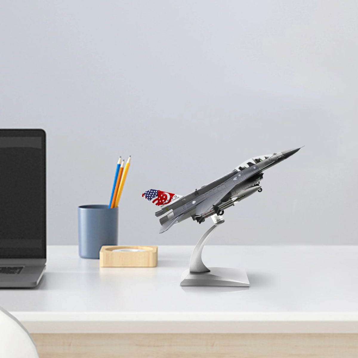 NUOTIE F-16D Fighting Falcon diecast model displayed on a stand in a workspace setting