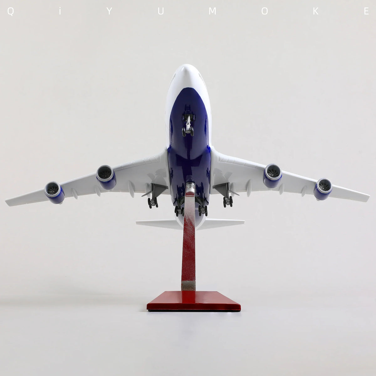 QIYUMOKE Boeing 747 airplane model in white and blue with red accents, front view on display stand