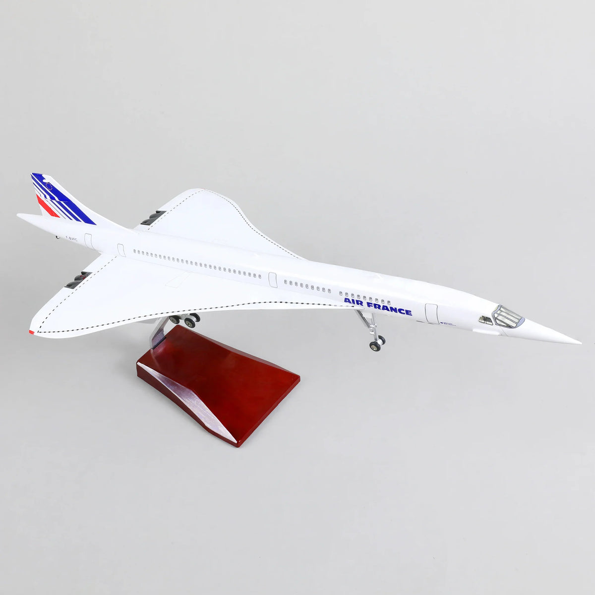QIYUMOKE Concorde Air France diecast airplane model in white with blue and red accents, top view on wooden base