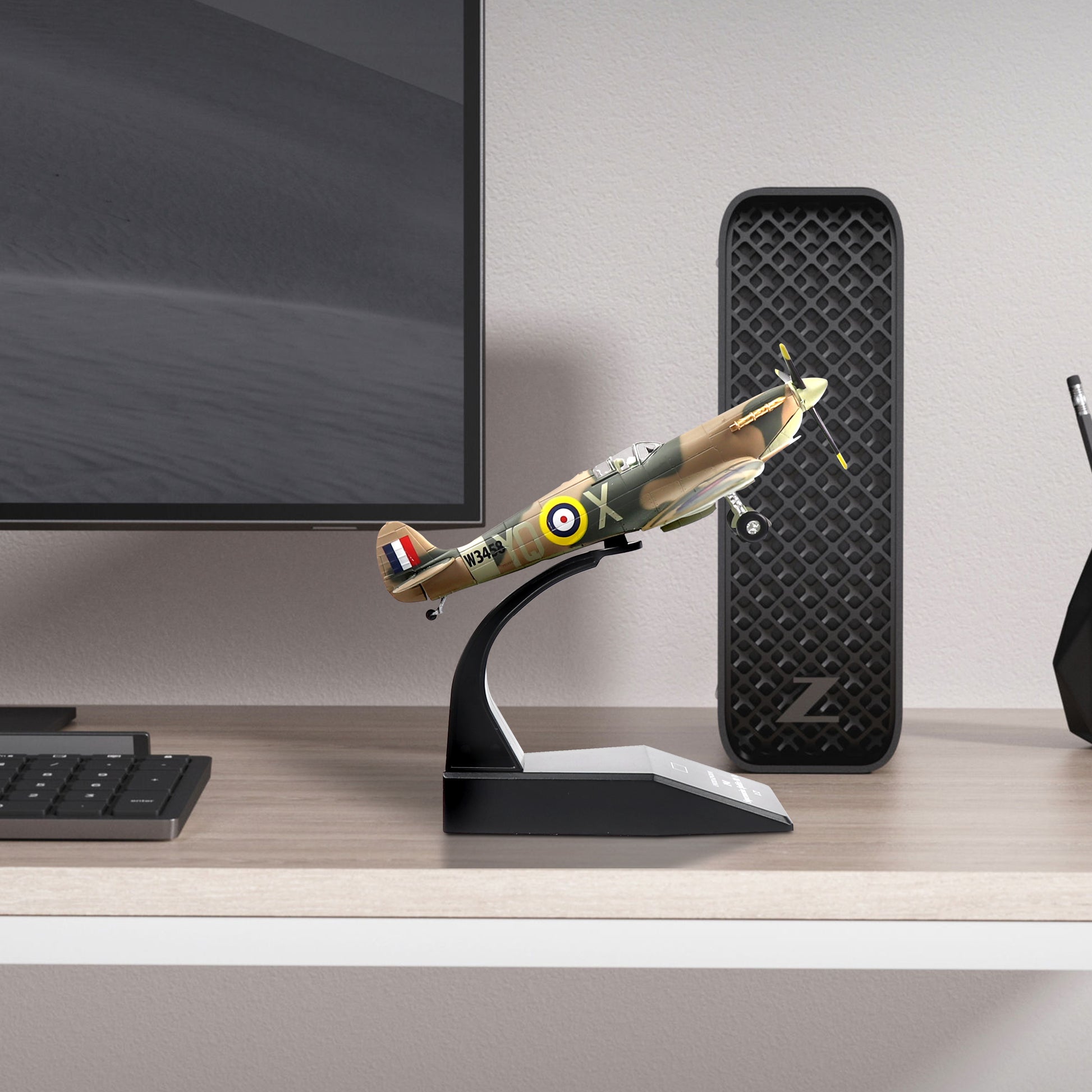 NUOTIE Supermarine Spitfire diecast model displayed on a stand on a desk